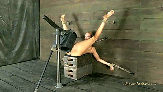 Lying on the wooden boxes all naked blonde is fucked with sex machine
