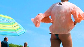 Playful nude beach girl caught on camera tanning