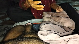 A desi wife massaging her husband's member with oil using her soft hands at night.