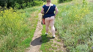 A fat woman walks through the park shows her ass and masturbates