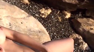 Alone lush Russian babe toys her cunt on the rock on the sea shore