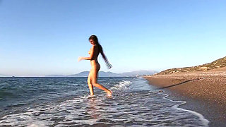 Young beauty Maria Tara caresses herself on the beach