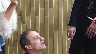 Fur-clad Femdoms Dominate Submissive on Balcony