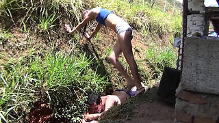 Nude babe stomping her slave in the backyard